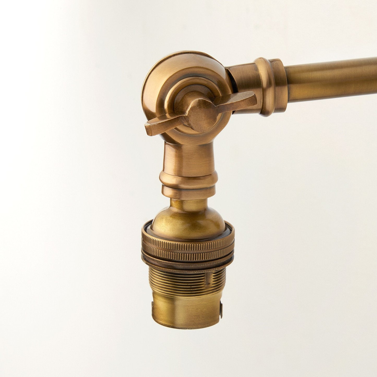 Double jointed wall fitting in antiqued brass