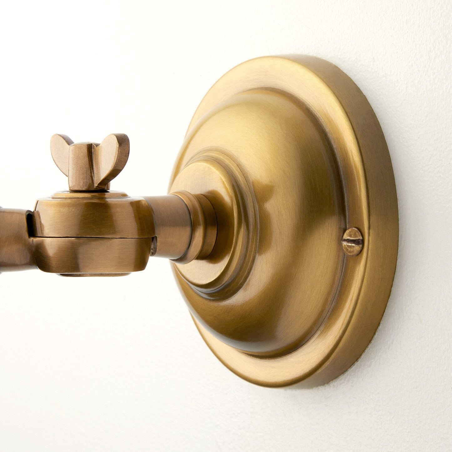 Double jointed wall fitting in antiqued brass