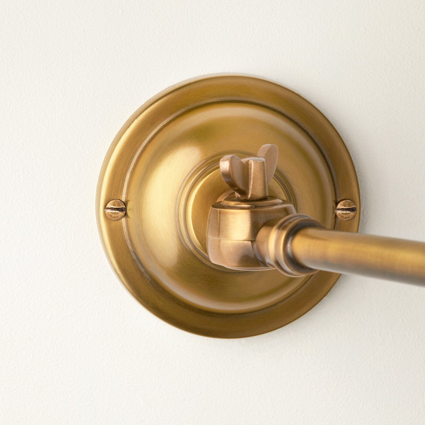 Double jointed wall fitting in antiqued brass